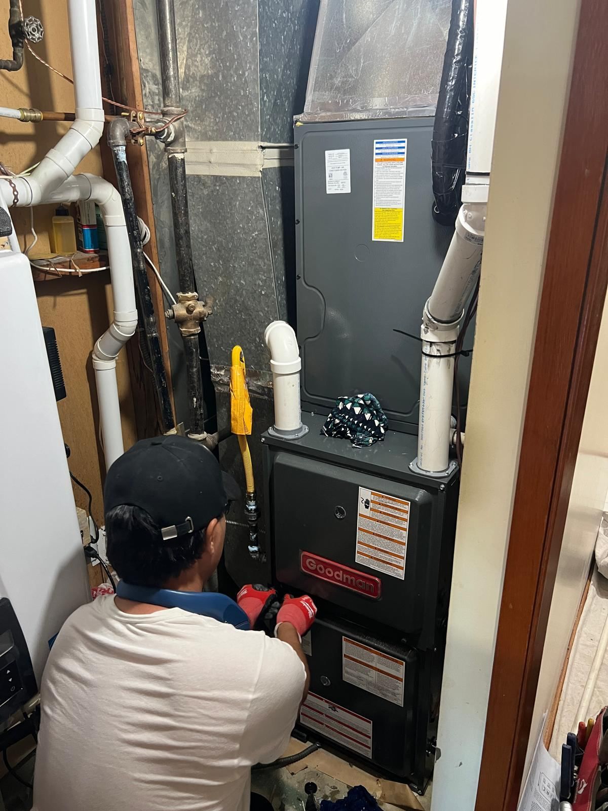 Technician installing Goodman high-efficiency furnace for dual fuel system