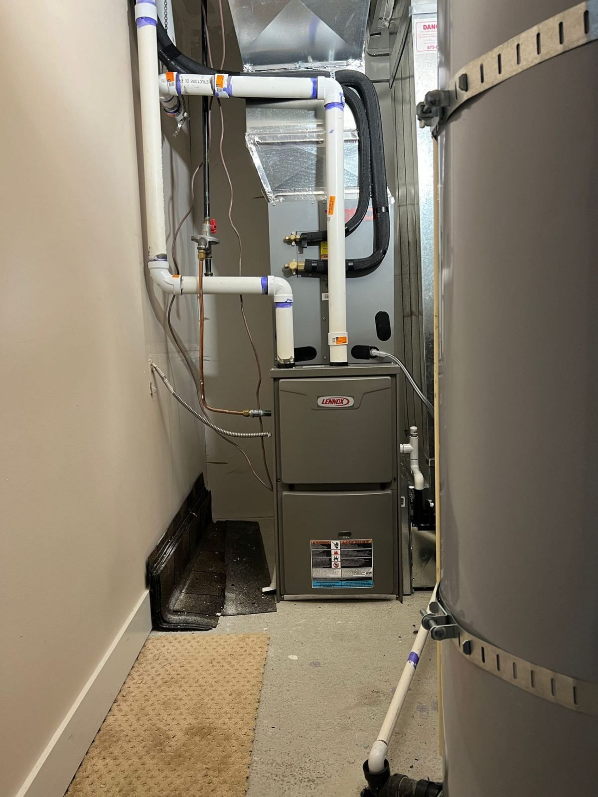 Lennox high-efficiency furnace installed in utility room with water heater tank
