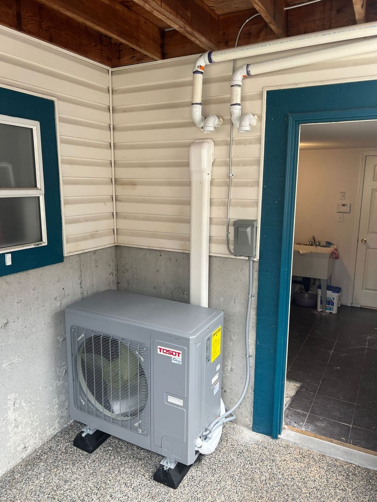 Tosot outdoor heat pump condenser installed in covered area